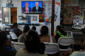 Migrants watch the first U.S. presidential debate at a shelter, in Tijuana