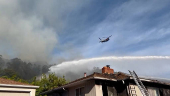 Firefighters work to stop a fire that damaged homes, in Oakland