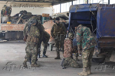 Rebel fighters stand together in Homs countryside