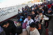 Migrants gather at El Chaparral border crossing after their CBP One app asylum appointment was cancelled on the day of U.S. President Donald Trump's inauguration, in Tijuana