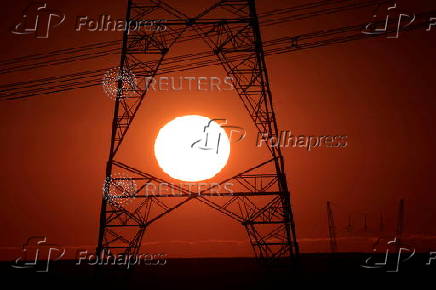 FILE PHOTO: Power lines connecting pylons of high-tension electricity are seen during sunrise near Brasilia