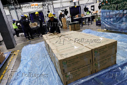 Workers handle boxes of flowers for export before Valentine?s Day, in Quito