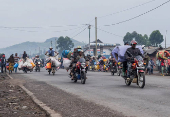 Internally displaced civilians from the camps in Munigi and Kibati, carry their belongings as they flee to Goma