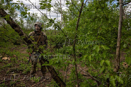 A Ukrainian serviceman of the 22nd Separate Mechanised Brigade stands near an artillery position on the outskirts of Chasiv Yar