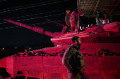 Israeli soldiers gather near a military vehicle after returning from Lebanon, following a ceasefire between Israel and Iran-backed group Hezbollah, near Kiryat Shmona