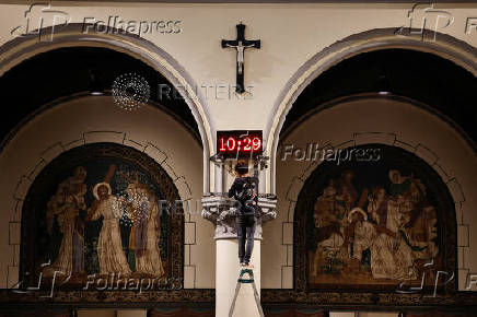 A man sets a digital clock to prepare for the Christmas mass at the Jakarta Cathedral in Jakarta