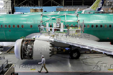 FILE PHOTO: A worker walks past Boeing's 737 MAX-9 under construction at their production facility in Renton, Washington