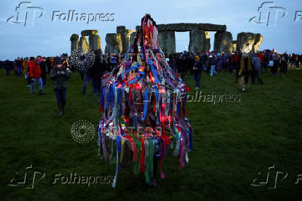 Revellers attend winter solstice celebrations during sunrise at Stonehenge stone circle near Amesbury