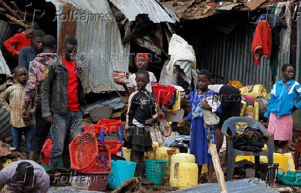 Residents stand beside their belongings after the Nairobi river burst its banks and destroyed their homes within the Mathare Valley settlement in Nairobi