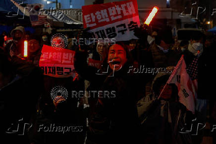 Pro-Yoon protesters are seen in the early light after rallying throughout the night in support of impeached South Korean President Yoon Suk Yeol near his official residence, in Seoul