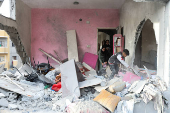 Palestinians inspect damage at the site of an Israeli strike on a house, at Nuseirat refugee camp