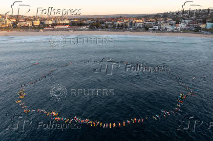 Members of the Bondi Board Riders Club, as well as various local sporting clubs and lifeguards, participate in a Paddle Out to honour and remember those affected by the recent attack at Westfield Bondi Junction, at Bondi Beach in Sydney