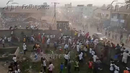 People scramble in Nzerekore where local officials said a stampede occurred following clashes at a soccer match