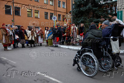 People dressed in traditional clothes sing carols for injured service members in Kyiv