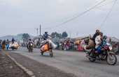 Internally displaced civilians from the camps in Munigi and Kibati, carry their belongings as they flee to Goma