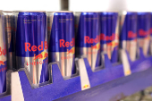 Cans of Red Bull Energy Drink are displayed on a shelf in a supermarket