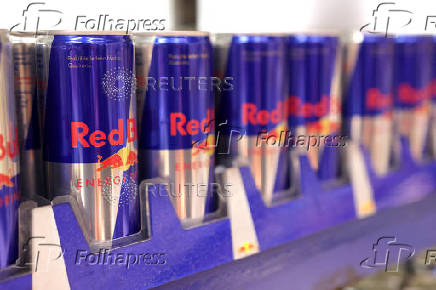 Cans of Red Bull Energy Drink are displayed on a shelf in a supermarket