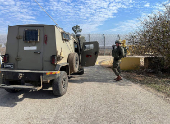 An Israeli soldier uses a phone next to a military vehicle in the Israeli-occupied Golan Heights near the border with Syria