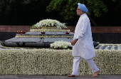 FILE PHOTO: Indian Prime Minister Manmohan walks at the memorial of the former prime minister Gandhi on the occasion of the former prime minister's 69th birth anniversary in New Delhi