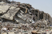 Palestinians search for salvageable items through the rubble of a residential building destroyed by Israeli strikes, amid the ongoing conflict between Israel and Hamas, in the northern Gaza Strip