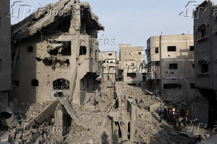 Palestinians inspect damage at the site of an Israeli strike on a house, at Nuseirat refugee camp