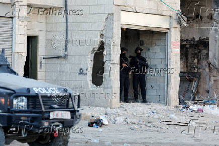 Palestinian security forces patrol amid clashes with militants at the camp in Jenin