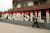 A boy walks past an 'I love Qamishli' sign in Qamishli