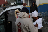 People wait in line for clean needles and other harm reduction items in Harlem, New York City