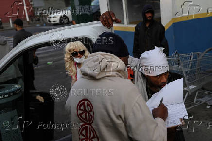 People wait in line for clean needles and other harm reduction items in Harlem, New York City