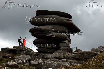People react as they reach the climb up to a natural structure known as The Cheesewring