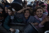 Displaced Palestinians collect donated food in Khan Yunis, southern Gaza