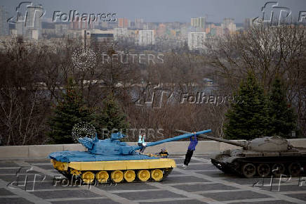 Children play on top of a tank put on display in front of the Motherland Monument in Kyiv