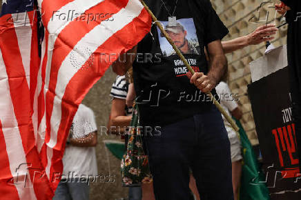 A family member of Tof Hersh Goldberg-Polin, an Israeli-American seized during the October 7 attack on Israel and taken hostage into Gaza, holds a U.S. flag before a news conference in Tel Aviv