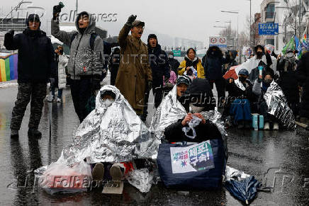 People take part in a protest against the impeached South Korean President Yoon Suk Yeol near his official residence on a snowy day in Seoul