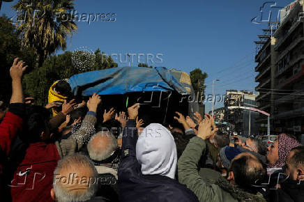 People gather around a truck to receive bread in Aleppo