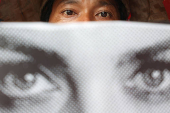 A demonstrator carries a placard as he takes part in a rally during Human Rights Day in Jakarta