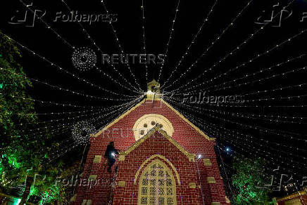 A man installs decorative lights on a church ahead of Christmas celebrations in Ahmedabad