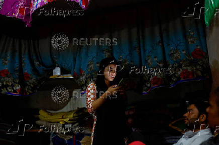 Muskan,16, types on a mobile phone as Tofik and Nasreen look at their daughter at their residence in Loni town in the northern state of Uttar Pradesh