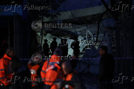 Emergency services personnel work near a damaged site after a projectile fired from Yemen was intercepted, in Ramat Gan