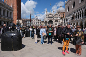 Tourists walk in St Mark's Square on the day Venice municipality introduces a new fee for day