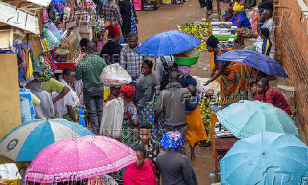 Residents walk at an open air grocery market in the outskirts Kigali