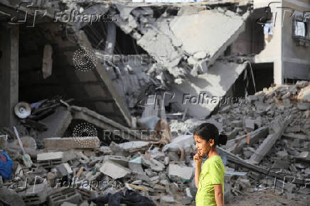 Palestinians inspect the site of an Israeli strike on a house in Rafah