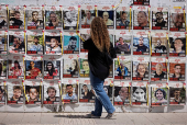 A woman walks past posters of hostages kidnapped during the deadly October 7 attack by Palestinian Islamist group Hamas, in Tel Aviv