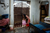 Muskan,16, Tofik and Nasreen's daughter, plays with a girl  at her residence in Loni town in the northern state of Uttar Pradesh