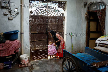 Muskan,16, Tofik and Nasreen's daughter, plays with a girl  at her residence in Loni town in the northern state of Uttar Pradesh