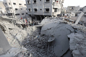 Palestinians inspect damage at the site of an Israeli strike on a house, at Nuseirat refugee camp