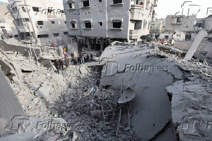 Palestinians inspect damage at the site of an Israeli strike on a house, at Nuseirat refugee camp