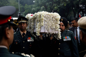 Military officers carry the coffin with the mortal remains of India's former PM Singh at the Congress party's headquarters in New Delhi