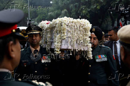 Military officers carry the coffin with the mortal remains of India's former PM Singh at the Congress party's headquarters in New Delhi