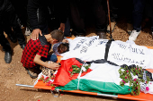 People mourn two Palestinians who were killed during an Israeli settlers' attack on Aqraba